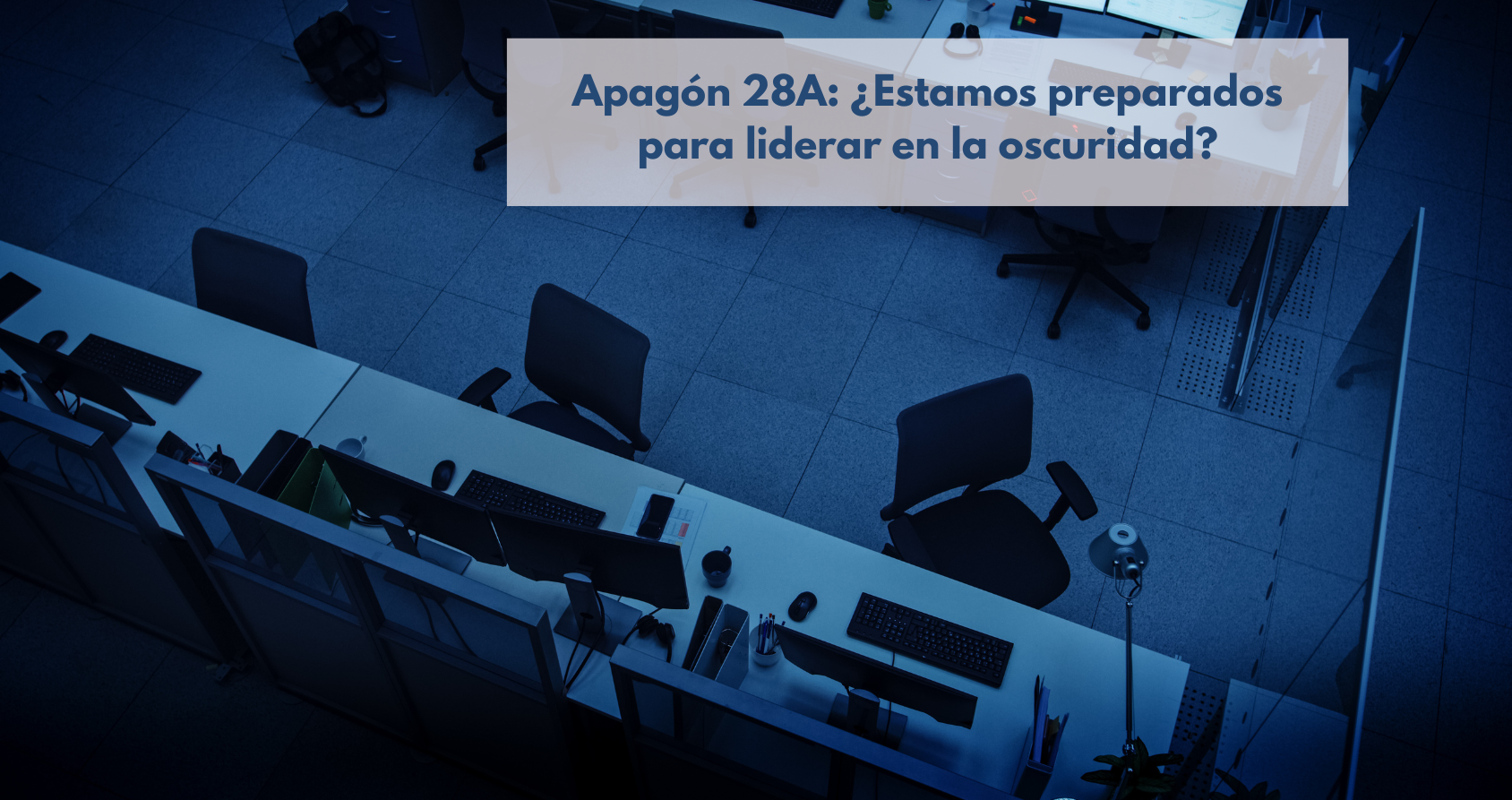 Oficina a oscuras durante el apagón 28A, con solo luces de emergencia encendidas, reflejando la parálisis empresarial y la importancia de la continuidad del negocio.