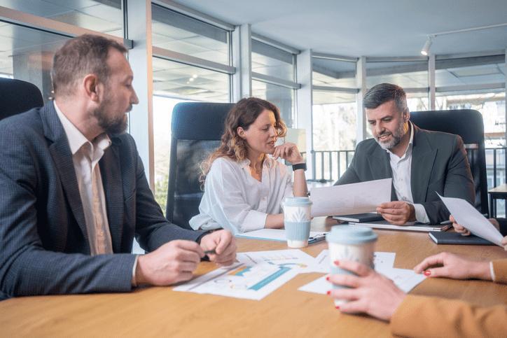 Directiva revisando indicadores financieros en la sala de reuniones de una empresa industrial